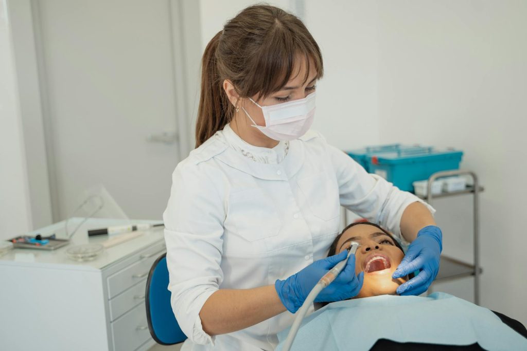 Dentist performing a routine dental check-up on a patient in a modern clinic setting.