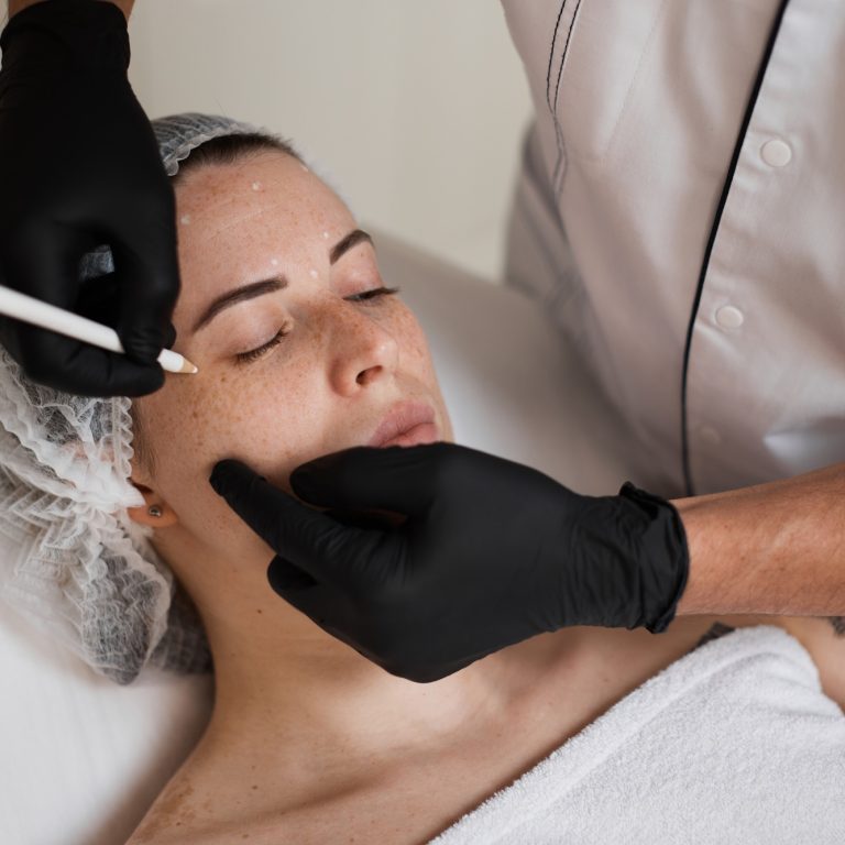 cosmetologist marking skin of caucasian woman with pencil.