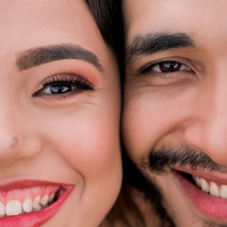 man and woman smiling while taking selfie